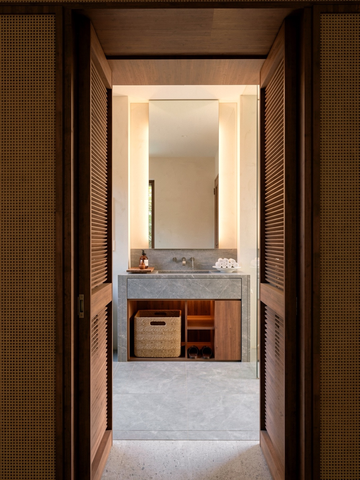 Ensuite framed by dark timber and woven cane doors